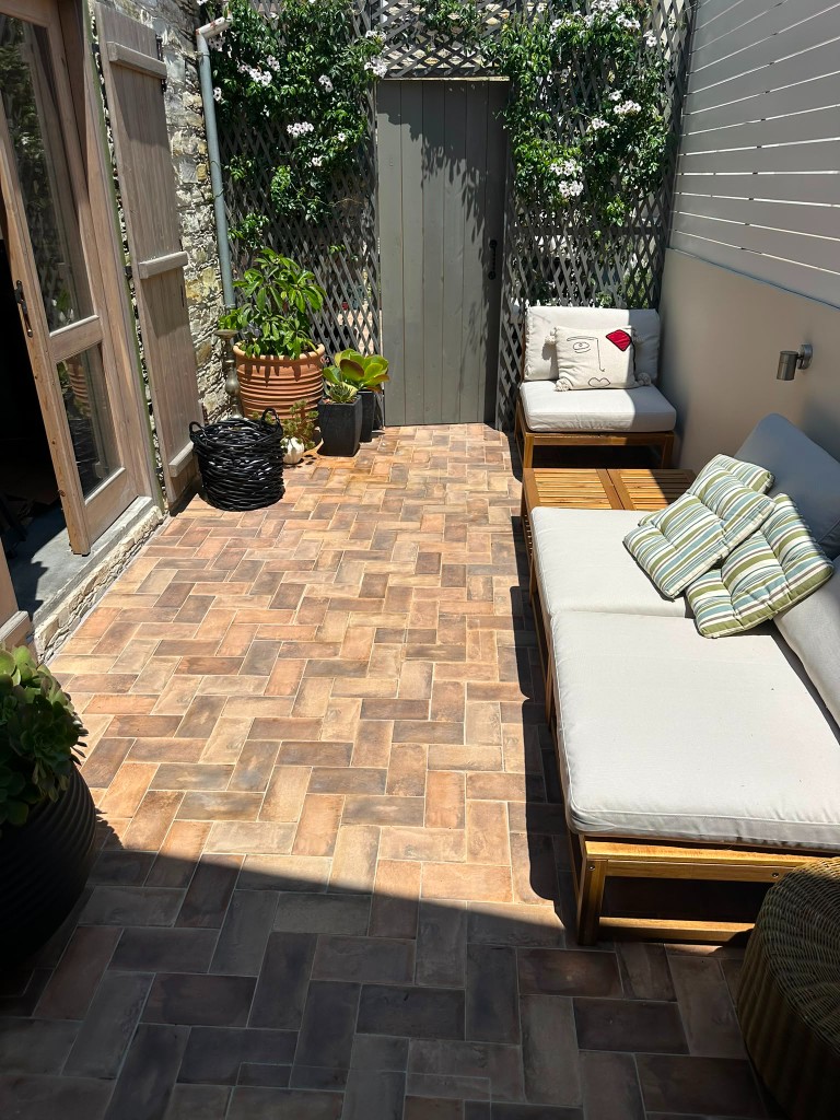 Sunlit private courtyard with herringbone tiles and outdoor seating