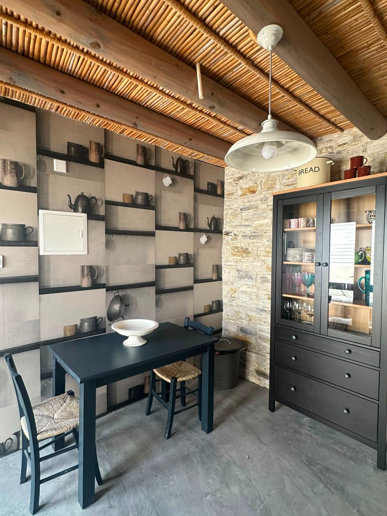 Rustic dining nook with exposed stone wall and wooden hutch