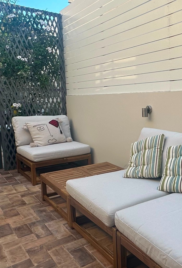 Outdoor patio with wooden lounge chairs and striped cushions